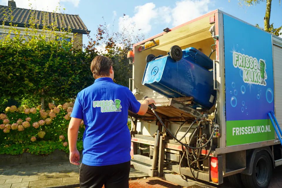 Een container wordt achter op de reinigingswagen van Frisse Kliko gekanteld.
